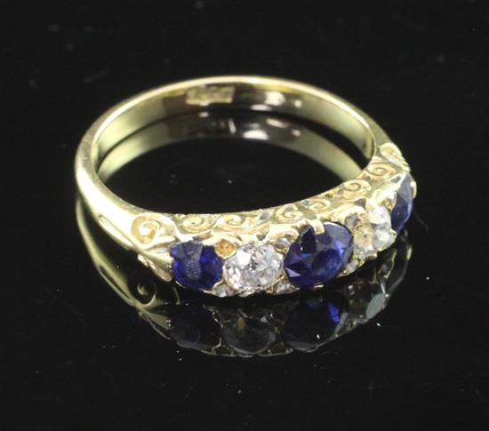 An early to mid 20th century 18ct gold sapphire and diamond half hoop ring, size O.